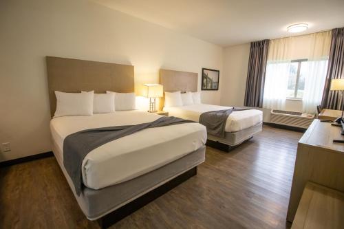 a hotel room with two beds and a desk at The Tillamook Inn in Tillamook