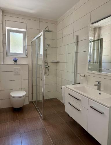 a bathroom with a toilet and a sink and a shower at Apartments Elin in Omiš