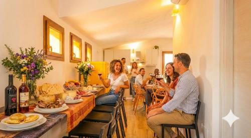 a group of people sitting around a table with food at La Grotta Sardegna 5 Bedrooms each with a Private Ensuite Bathroom featuring a Hydromassage Shower Air Conditioning in Urzulei