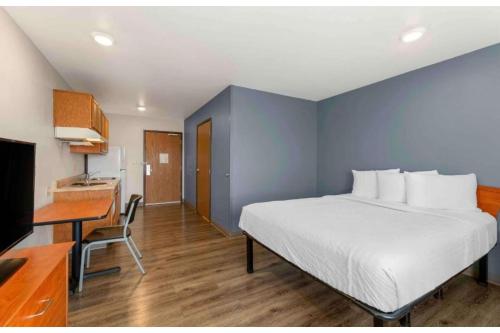 a bedroom with a bed and a desk with a computer at Studio 6 Extended Stay Birmingham Pelham AL in Pelham