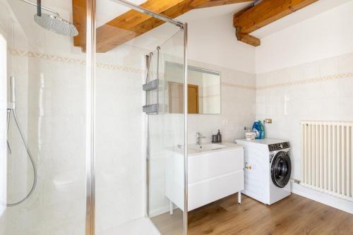 a bathroom with a shower and a washing machine at Appartamento Vittoria in Cles