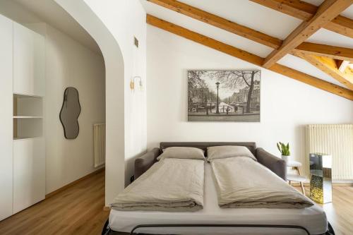 a bedroom with a bed in a room with wooden ceilings at Appartamento Vittoria in Cles