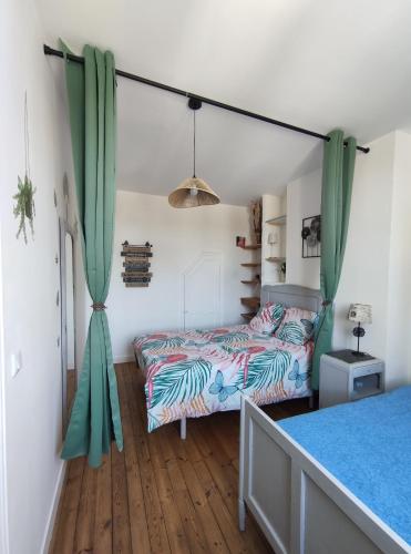 a bedroom with two beds and green curtains at Le Clos du Val in Chivres-Val