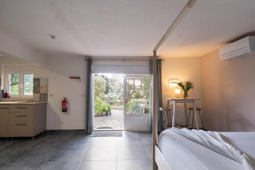 a bedroom with a bed and a door to a yard at Quinta da Cerejeira in Ferreira do Zêzere