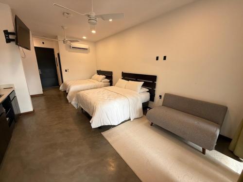 a bedroom with two beds and a couch at Isabel 203 Space, light and calm! in Nicoya