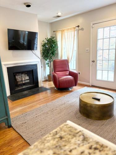 a living room with a red chair and a fireplace at Downtown House Free On-site Parking A in Washington, D.C.