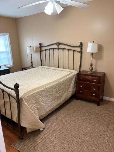 a bedroom with a bed and a dresser and a fan at Downtown House Free On-site Parking A in Washington, D.C.