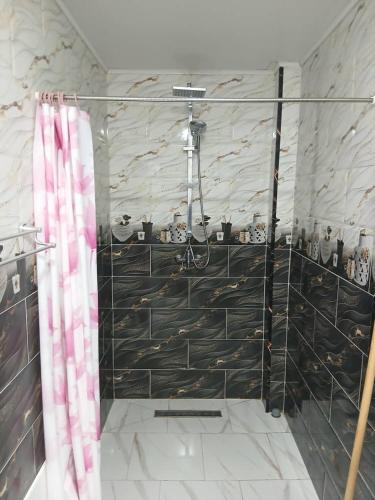 a shower with a glass door in a bathroom at Appartement Saket Plage in Taranimt