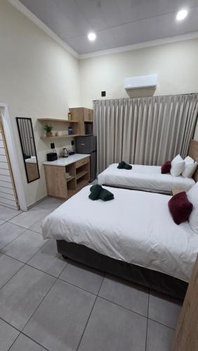 a bedroom with two beds and a desk in it at Morgenzon Lodge in Morgenzon