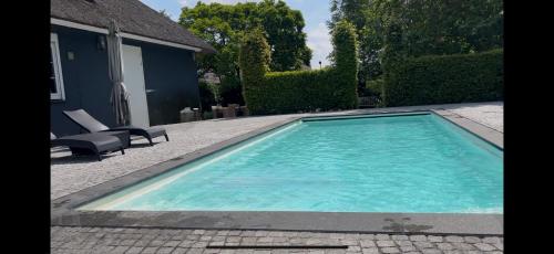 a swimming pool in front of a house at Villa France in Sevenum