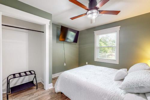 a bedroom with a bed and a ceiling fan at Mardi Gras Parade, Walk to Beach! Bay St Louis Gem in Bay Saint Louis