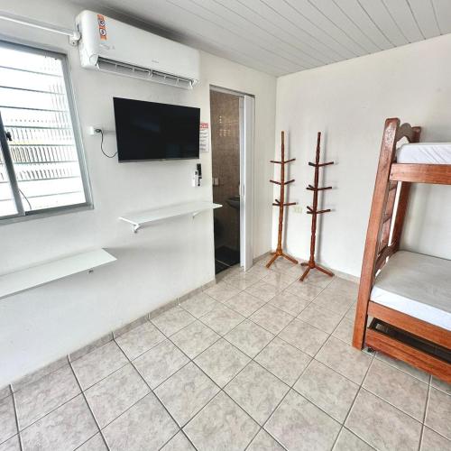 a room with a flat screen tv on a wall at Anexo - Pousada Canaã in Recife