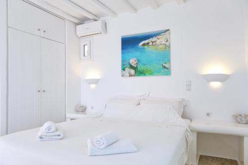 a white bedroom with a bed and a sink at La Maison Blanche in Agios Stefanos