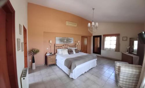 a large bedroom with a large bed and a chandelier at Ambelli Villa 4 Bedroom Luxury Villa in Skarinou