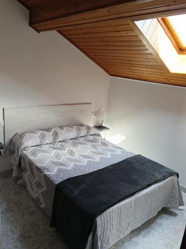 a bedroom with a large bed with a window at Rías Baixas in Villanueva de Arosa