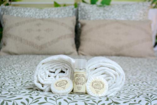 a bed with two towels and a bottle of lotion at Live Oporto Rooms in Porto