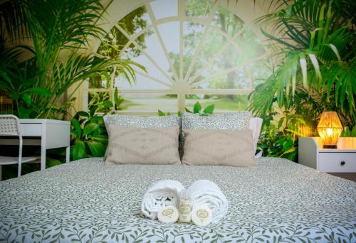 a bed with a pair of slippers and towels on it at Live Oporto Rooms in Porto
