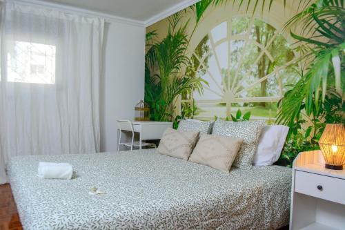 a bedroom with a bed with plants on the wall at Live Oporto Rooms in Porto