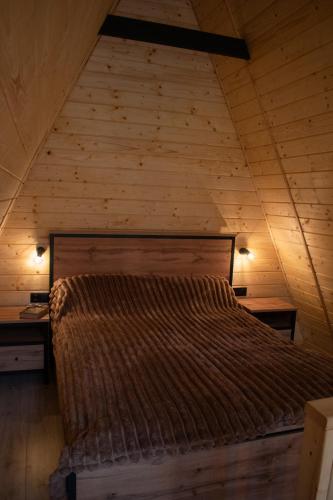 a bed in a room with a wooden wall at Skala House in Skole