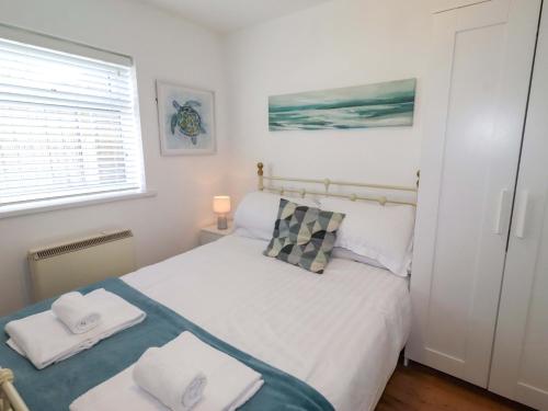 a bedroom with a bed with two towels on it at Sunrise Cottage in Chathill