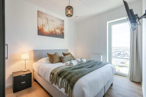 a bedroom with a large bed and a large window at Casiola - Bright apartment with seaview in Bredene