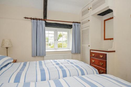 a bedroom with a bed and a window at Tumrose Cottage in Blisland