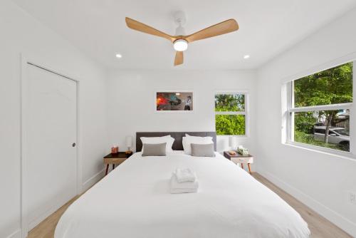 a white bedroom with a large bed with a ceiling fan at Havana House Miami in Miami