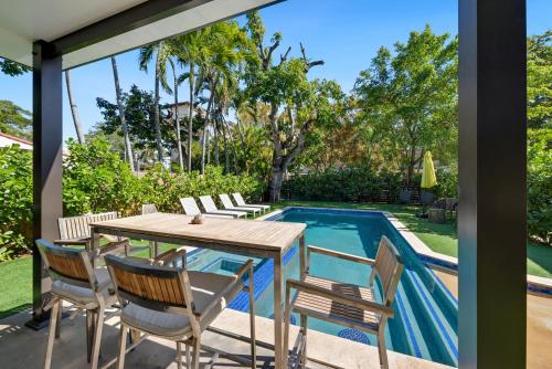 a patio with a table and chairs next to a pool at Havana House Miami in Miami