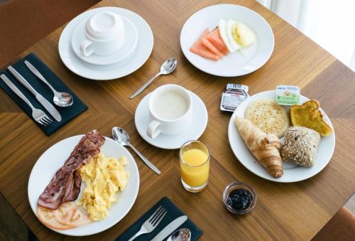 a wooden table topped with plates of breakfast foods at 19 Tile Ceramic Concept - by Unlock Hotels in Caldas da Rainha