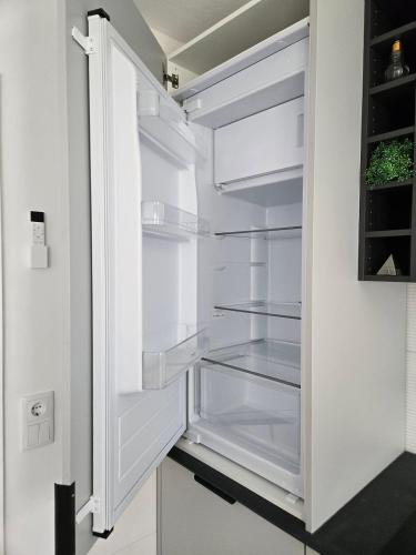 an empty refrigerator with its door open in a kitchen at Suzi's Garden Aveiro in Aveiro