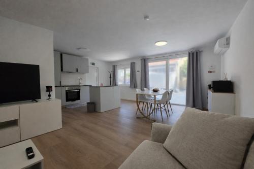 a living room with a couch and a kitchen with a table at Suzi's Garden Aveiro in Aveiro