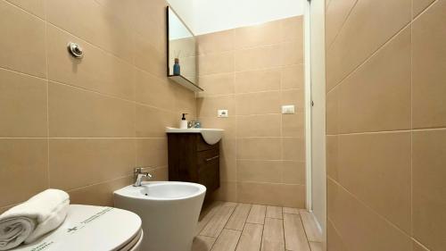 a bathroom with a toilet and a sink and a mirror at Le casette di Frà Studios in Santa Severa