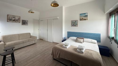 a bedroom with a bed and a couch at Le casette di Frà Studios in Santa Severa