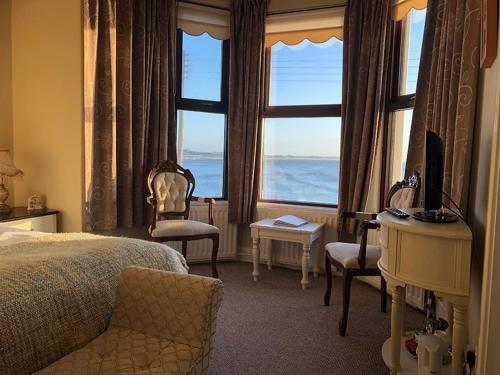 a bedroom with a bed and a desk and a window at Dacara Bed & Breakfast in Newcastle