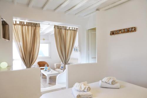 a white room with a bed and a mirror at La Maison Blanche in Agios Stefanos