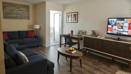 a living room with a blue couch and a tv at West LA Boutique Apartments Minutes from the Coast in Los Angeles