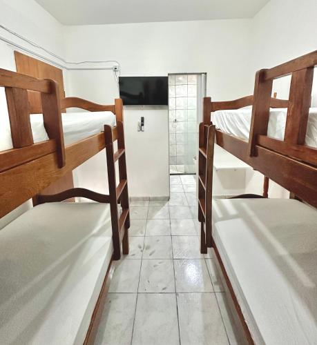 a room with two bunk beds and a bathroom at Anexo Térreo - Pousada Cannã in Recife