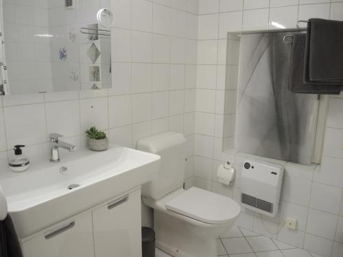 a white bathroom with a toilet and a sink at La Margaritta by Fewotessin in Minusio