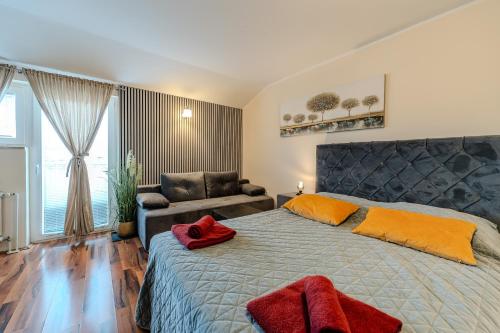 a bedroom with a large bed and a couch at Apartments Bracic Spa in Sukošan
