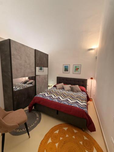 a bedroom with a large bed and a chair at La Casa di Lili in Nardò