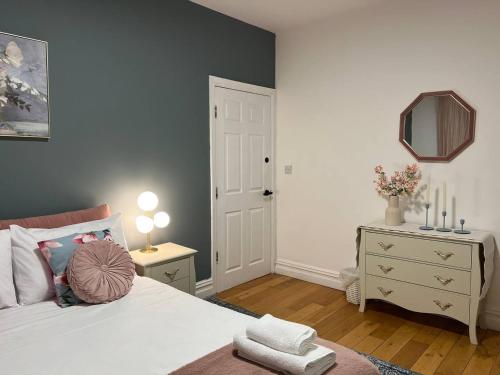 a bedroom with a white bed and a mirror at Zozy Gladstone in London