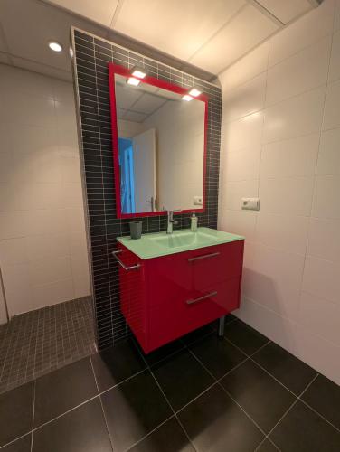 a bathroom with a red sink and a mirror at Casa Diego in Alcañiz