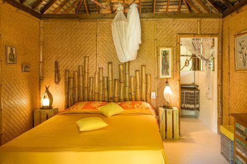 a bedroom with a large yellow bed with yellow pillows at Charming 1BR Garden Bungalow in Temae