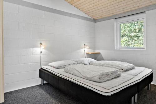 a white bedroom with a bed with two lights on it at 2613-Romo-Sneppen-7 in Høm