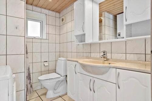 a white bathroom with a toilet and a sink at 2613-Romo-Sneppen-7 in Høm