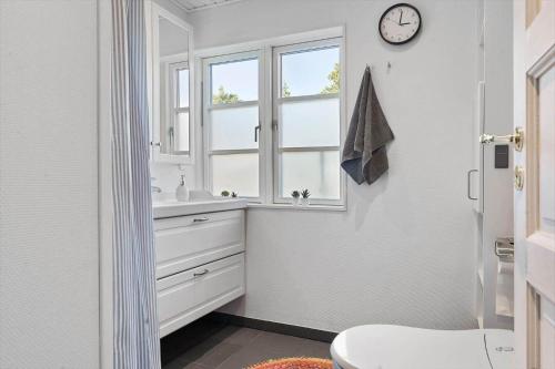 a bathroom with a sink and a clock on the wall at 2010-Romo-Moritzvej-10 in Høm