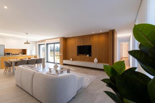 a living room with a white couch and a tv at Casa Da Luz in Lousada