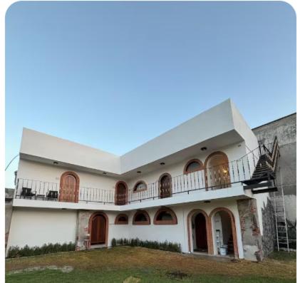 a large white building with a balcony on it at Hotel Boutique Santa Teresa in Tlazcalancingo