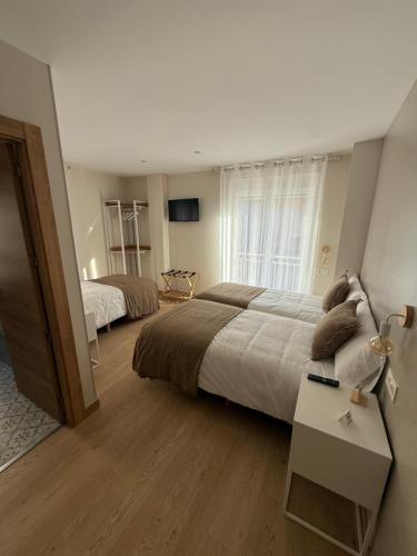 a hotel room with two beds and a window at Pensión el Horno REFORMADO in León