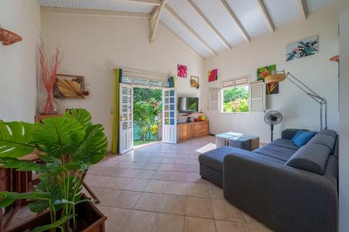 a living room with a couch and a tv at Villa Providencia jacuzzi 1 min plage Le Diamant in Le Diamant